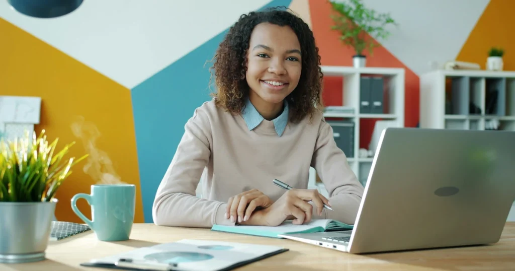 Coach souriante en home office travaillant sur le lancement de son business de coaching en ligne